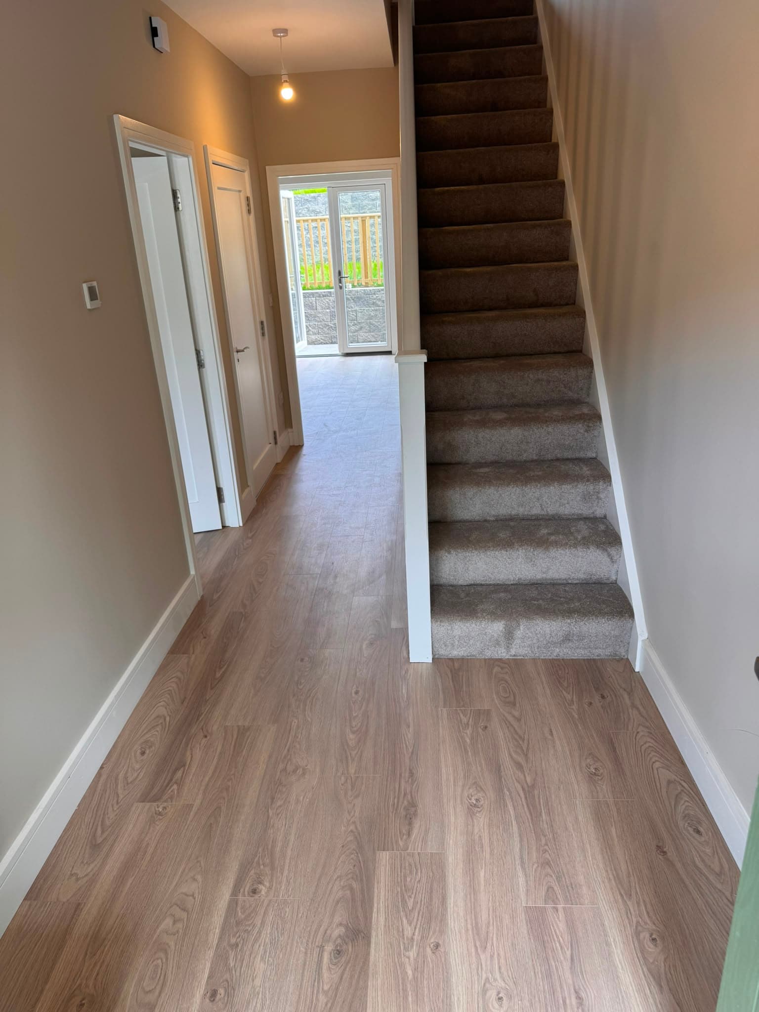 Hallway and staircase fitted with wood-effect laminate flooring by Philip B Flooring
